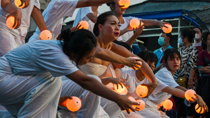 0823itn01 Chiang Rai-born Artist Waewdao Sirisook (center) and American and Thai actors and youth act out the “Disruption of Nature and the Giant Catfish Egg Extinction” scene at Chiang Khong Community Market along the Mekong River in Chiang Rai, Feb. 3. Photo courtesy of Thai News Pix