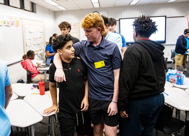 Noah Moon, CEO of CRAM or Creating Role Models and Mentors jokes with Fort Myers Middle Academy student, Adrian Fernandez during an after school session at the school on Wednesday, March 6, 2024. Noah plans on continuing the program once his brother goes to college. The program is also expanding to other Lee County schools.