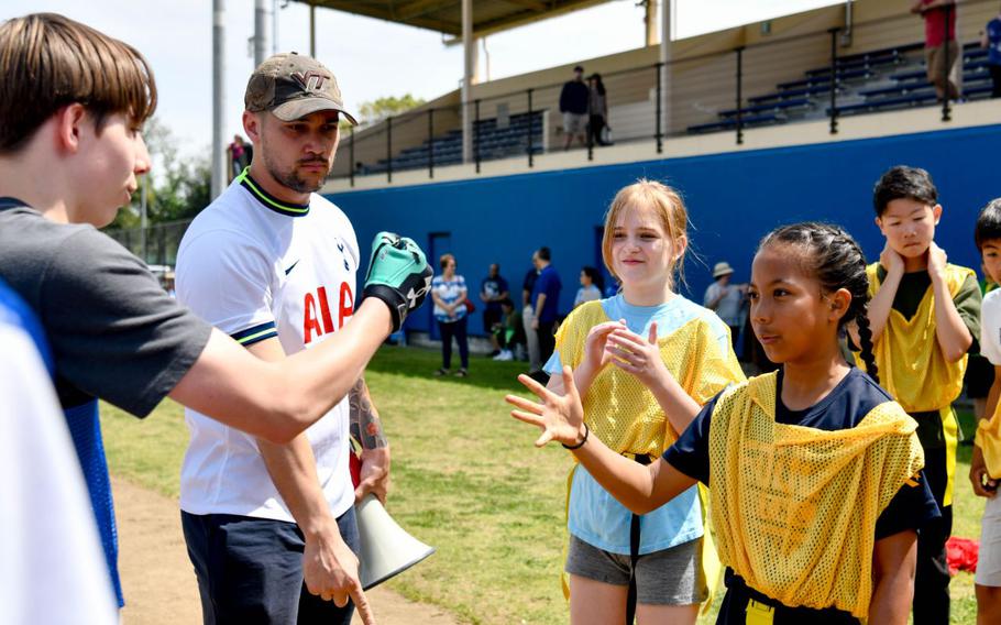Students play rock, paper, scissors to decide which team plays offense and defense for a flag football match at the eastside baseball stadium during the Sports Cultural Exchange Program kick-off event at Yokota Air Base, Japan, April 20, 2024. The SCEP is a new, multi-week event that allows for local Japanese and Yokota students to come together and share cultural experiences and sports.
