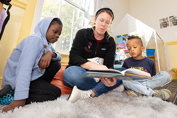 Teacher Chelsie Pastor reads a book to students at Care-O-World Early Learning Center in Winterville.