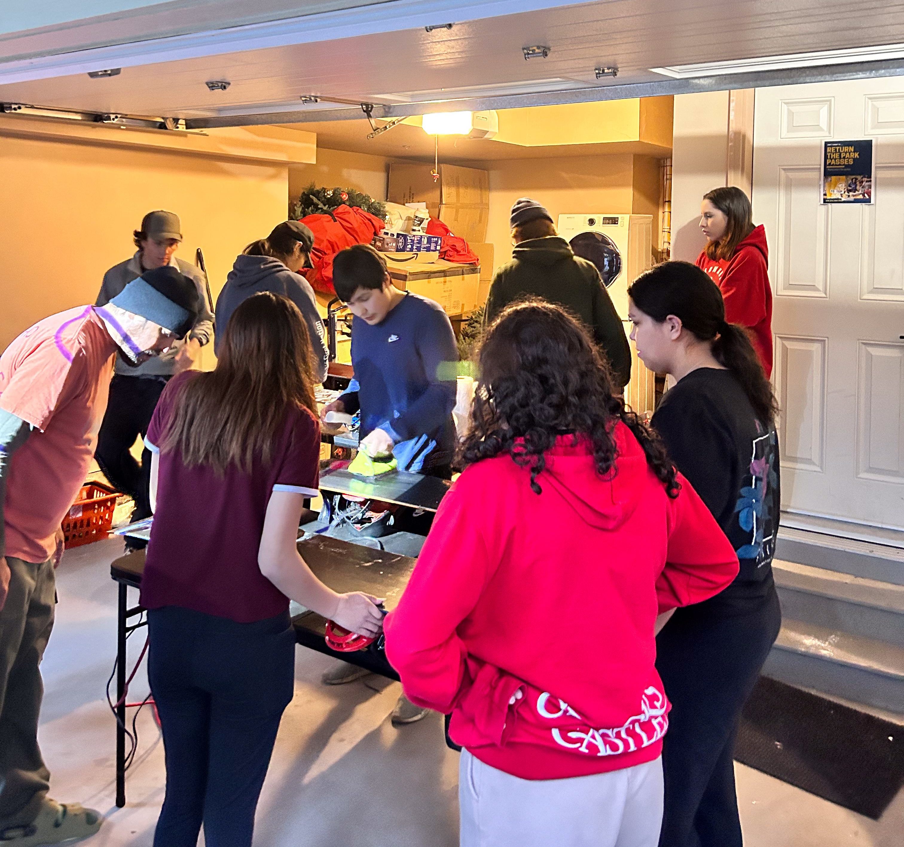 Young Indigenous snowboarders are shown how to wax their boards