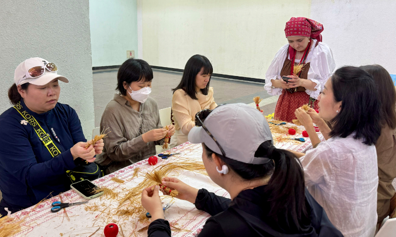 Visitors engage in hands-on activities at Russian exhibitors' booths in Beijing on Friday. Photo: Dong Feng/GT