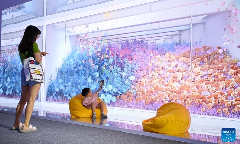 Visitors try a naked-eye 3D device in the digital culture exhibition area at the 10th West China Culture Industries Expo in Xi'an, northwest China's Shaanxi Province, Aug. 18, 2023. The 10th West China Culture Industries Expo opened on Thursday in Xi'an and will last till Aug. 20. The digital culture exhibition area of the expo features the latest achievements in the application of digital technology in the cultural industry, providing immersive experience of digital culture for the visitors. Photo: Xinhua