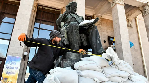 Getty Images A museum worker takes measures to protect a statue in Zaporizhzhia – monuments such as these are at risk of damage (Credit: Getty Images)
