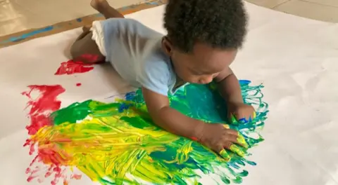 Chantelle Kuukua Eghan A baby painting on stretched out canvas