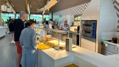 BBC People queueing for food at a canteen-style cafe at Gloucester Services