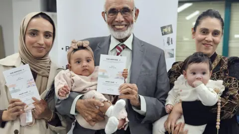 Aisha Iqbal/BBC Ahmed Lunat with granddaughters Aisha Laher and Sameeha Akudi, and baby great-granddaughters Safaa and Liyana