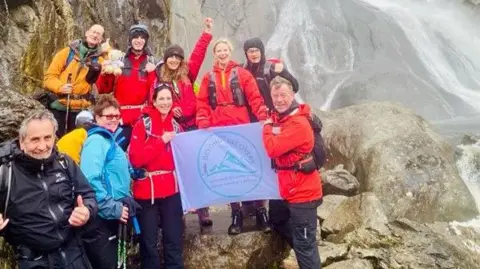 Sara Crosland A group of nine people including Sara Crosland on a previous mountain challenge, standing on a mountain