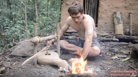 PrimitiveTechnology John Plant sat next to a fire in the woods