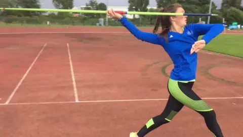 Family photo Molly Smith throwing a javelin at an athletics track in Merthyr