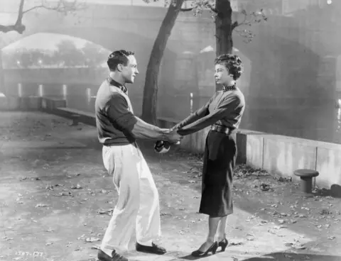 Michael Ochs Archives Gene Kelly hold Leslie Caron's arms in a scene from An American In Paris