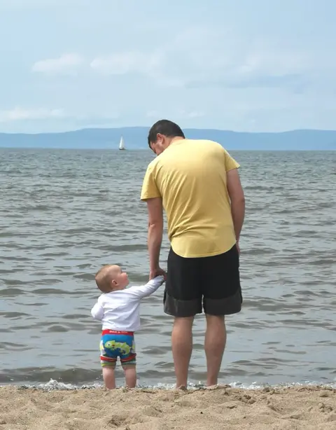 Maggie Smith Father and son at beach