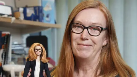 PA Media Undated handout photo issued by Mattel of Professor Dame Sarah Gilbert holding a Barbie doll of herself in honour of the Oxford vaccine co-creator.