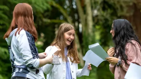 Getty Images Sophie Thomas (centre) celebrates after opening her GCSE results at Ffynone House School on August 12, 2021 in Swansea