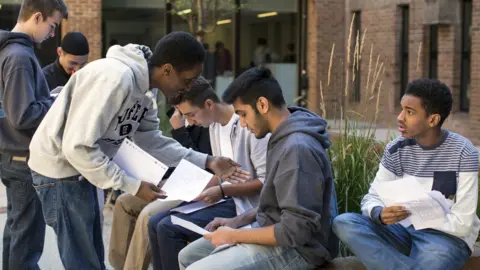 Getty Images Boys opening GCSE results in London