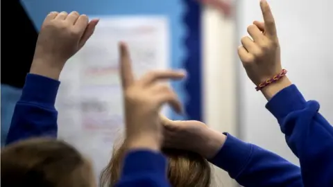 PA Media Pupils with hands in the air