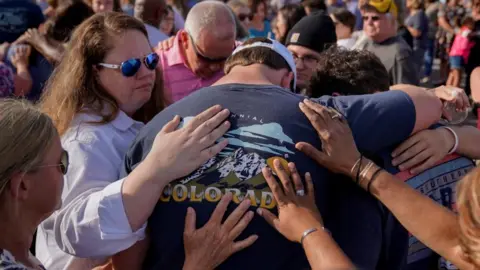Reuters People embrace at a vigil
