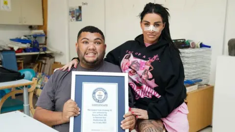 PA Media Katie Price and Harvey Price holding his Guinness World Record certificate