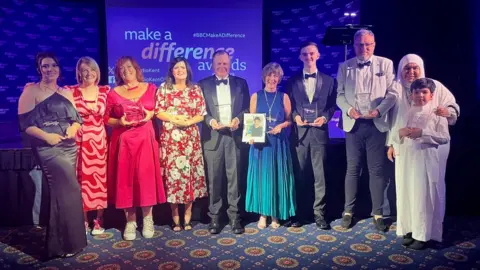 BBC The winners from this year's Make a Difference awards hold their awards
