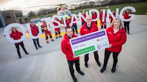 Midlands Air Ambulance Charity Midlands air ambulance staff holding outstanding sign