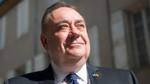 Getty Images A close-up of Alex Salmond looking off into the distance, wearing a dark blue suit, white shirt and blue tie.