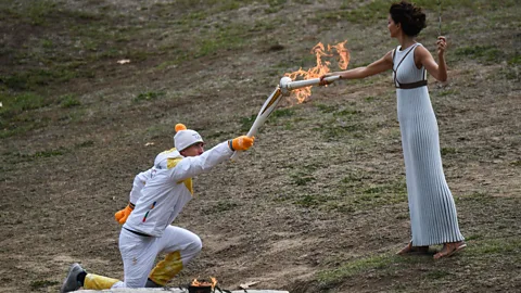 Getty Images The actress then uses the flame created by the sun to light the torch of the first bearer, usually a Greek athlete of note, for the start of the relay (Credit: Getty Images)