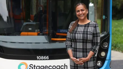 Stagecoach Woman standing next to a Stagecoach bus