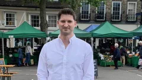 Will Tanner Will Tanner in from of market stalls
