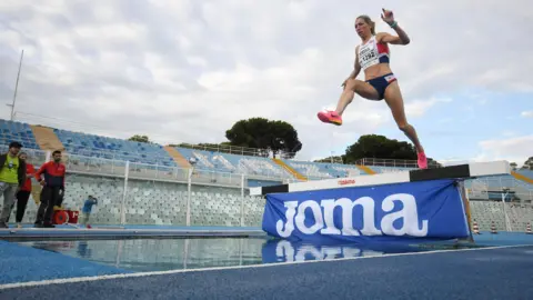 Kirstie Booth A woman jumps over water