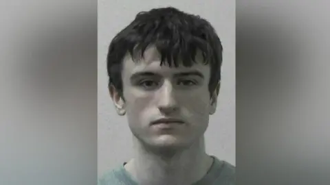 Northumbria Police Mugshot of MacPhail. He has dark eyes and mid length dark hair.