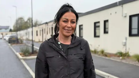 Kate Hollinshead from Vale of Glamorgan council stands in the street next to the new temporary homes.
