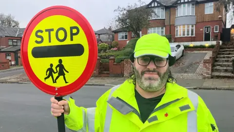 BBC Barry Jones with his lollipop stick on Bury Old Road in Heywood