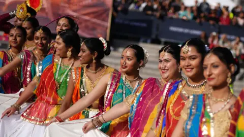 PA Media Dancers hold out their multicoloured Saris in a line during the Diwali on the Square celebration