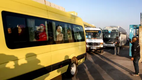 EPA Palestinian patients wave from a bus during an evacuation organised by the World Health Organization (WHO), at the European Hospital in Khan Younis, southern Gaza Strip (6 November 2024)