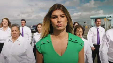 Mrs Buckét Rachael Flanagan, in a green dress, leads a group of workers from her cleaning company Mrs Buckét.