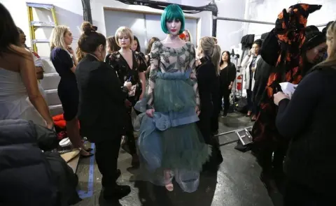 Getty Images Models prepare backstage