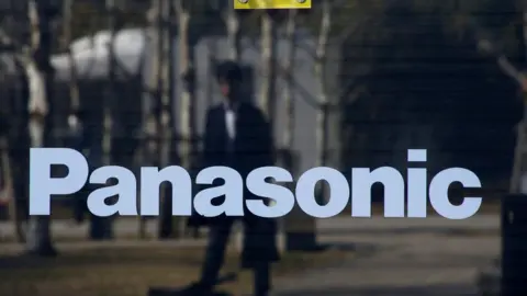 Reuters A man is reflected on Panasonic logo at Panasonic Center in Tokyo