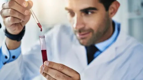 Getty Images Lab worker testing a blood sample