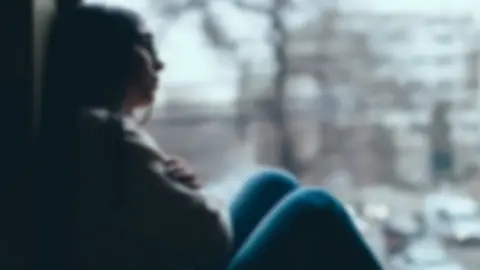 Getty Images Generic image of a teenager looking out of a window