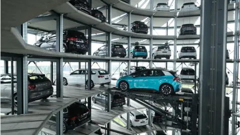 Getty Images A Volkswagen ID.3 electric car stands on an elevator platform inside one of the twin towers used as storage at the Autostadt promotional facility next to the Volkswagen factory