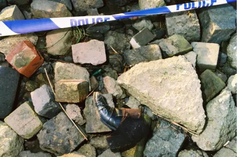Humberside Police Boot on rocks with police tape next to it