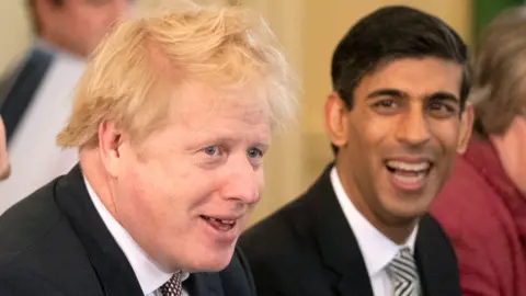 Reutes Britain's Prime Minister Boris Johnson speaks during his first Cabinet meeting next to a new appointed Chancellor of the Exchequer Rishi Sunak,