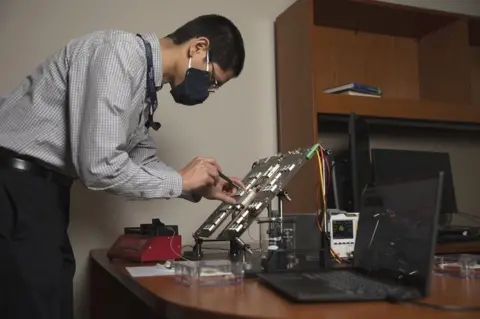 Sean McNeil GTRI's Nicholas Guise tests electronics on the microchip