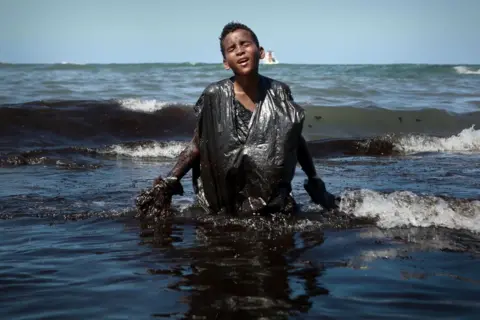 Getty Images A boy walks out of the sea tapuama beach located in the city of Cabo de Santo Agostinho, Pernambuco state, Brazil