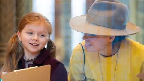 PA Media Artist Es Devlin helps a child with a still drawing at the Natural History Museum, in London, for the launch of The Wild Escape, a major new national campaign led by the Art Fund to respond creatively to the threat to the UK's natural environment