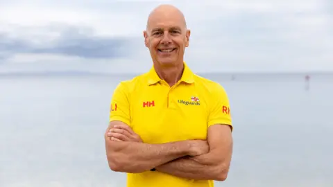RNLI Mr Greenslade standing in his RNLI uniform with arms crossed