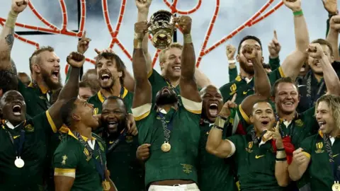 Yoan Valat/EPA-EFE/REX/Shutterstock Springboks captain Siya Kolisi holds the World Cup above his head