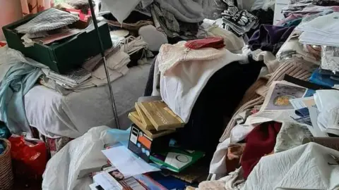 Helen Price Piles of clothes, books, newspapers and other items