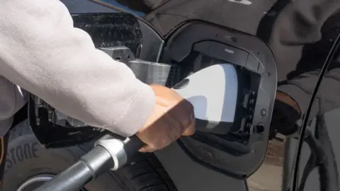 Getty Images A man charging an electric car