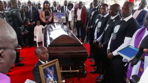 Reuters Family members surround the coffin of Kenya's marathon world record holder Kelvin Kiptum, who died in a road accident, during the funeral service at Chepkorio show ground, Elgeyo Marakwet County, Kenya February 23, 2024